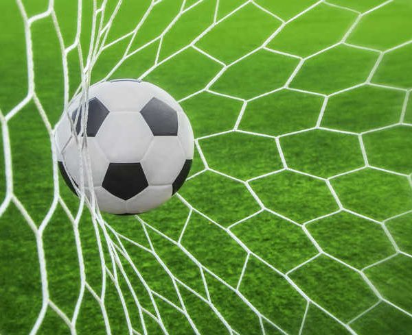 soccer ball in goal with green background