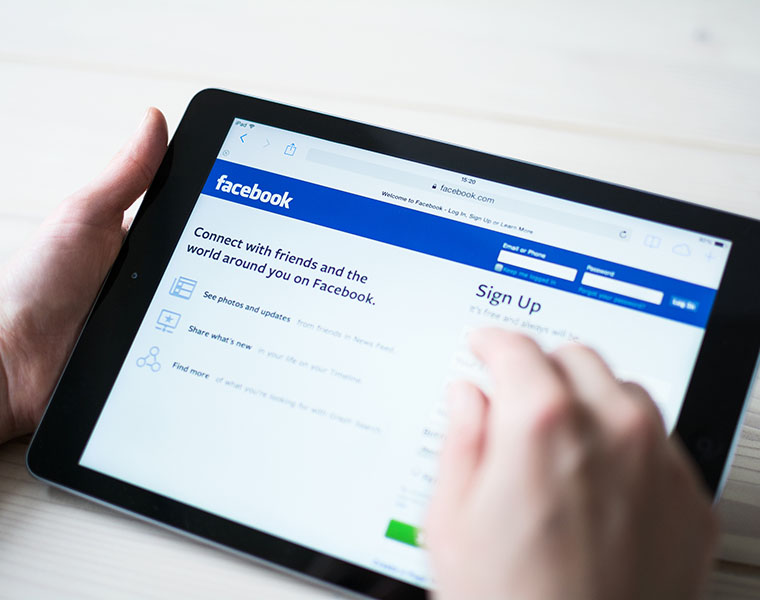 une personne sur sa tablette regarde le site facebook