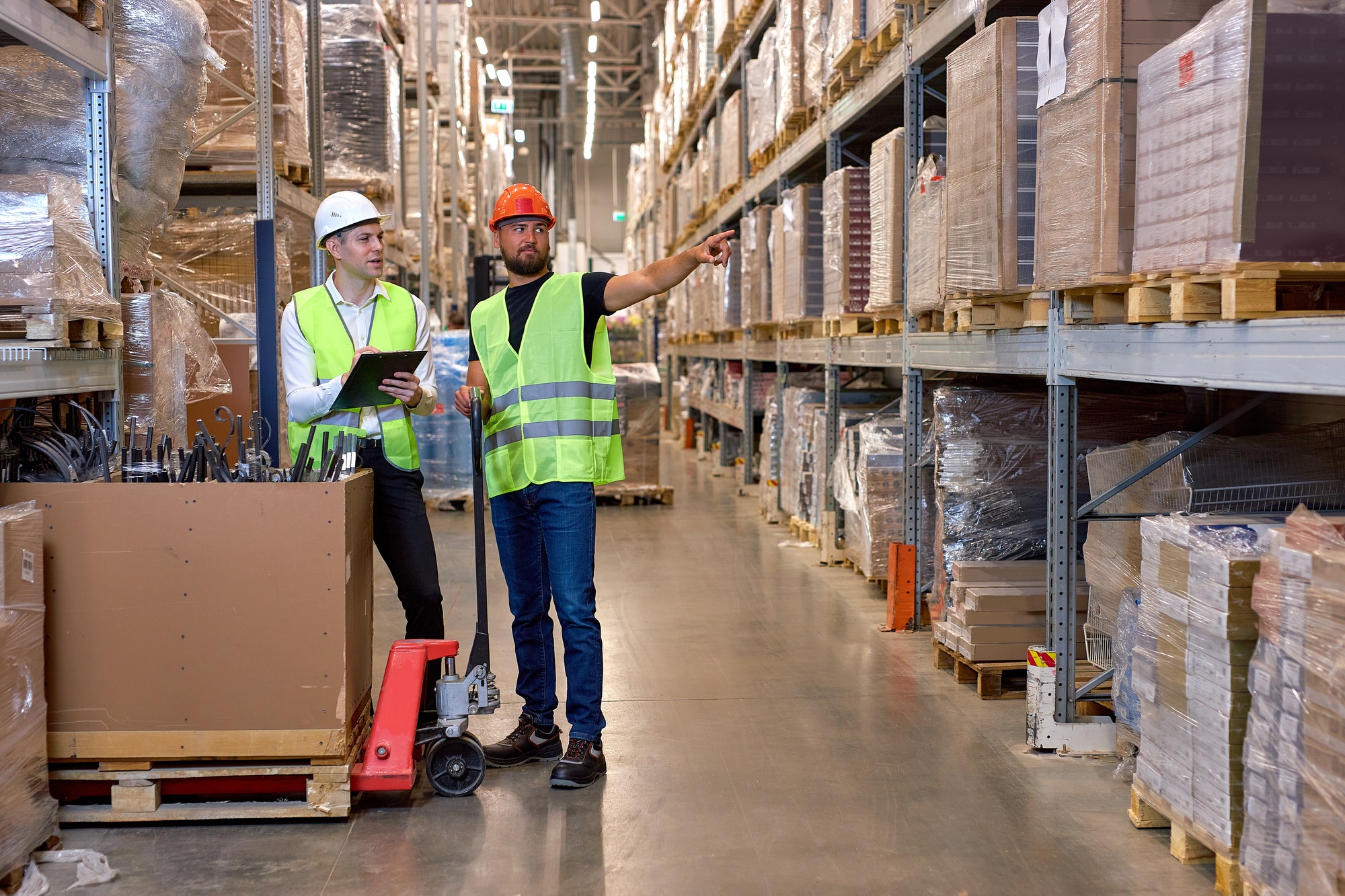 Warehouse managers walking through large warehouse distribution center discussing