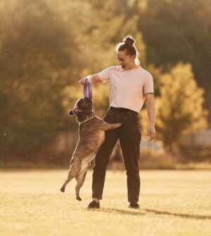 Woman is with dog on the summer field