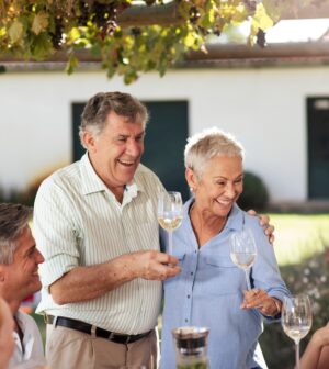 Happy senior couple with family having lunch together outside