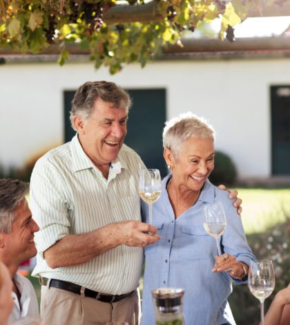 Happy senior couple with family having lunch together outside