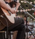 The musician plays and the lead singer sings on stage at the music festival.Concert
