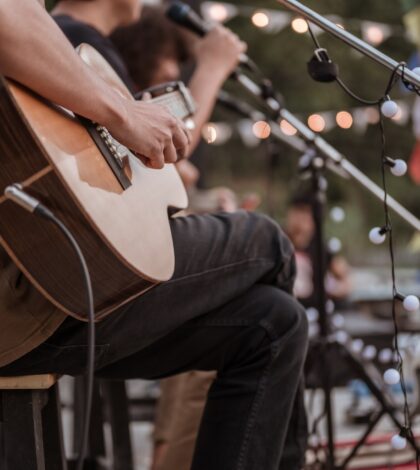 The musician plays and the lead singer sings on stage at the music festival.Concert