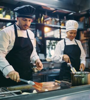 Two professional cooks working in the kitchen at restaurant.